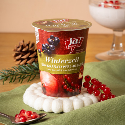 Winterzeitjoghurt Granatapfel auf einem Tisch drapiert