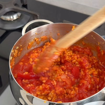 Bio-Soja Faschiert wird mit gehakten Tomaten und frischen Bio-Kräutern angebraten.