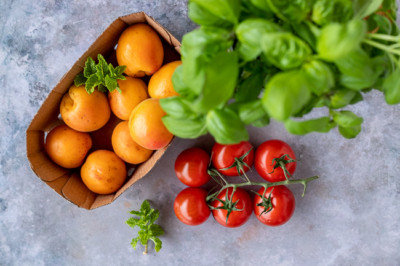 Bio-Marillen, Basilikum und Paradeiser auf einem Tisch.