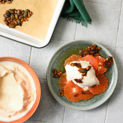 Das frisch zubereitete winterliche Frozen Joghurt ist in einer Schüssel mit Bio-Zitrusfrüchten.