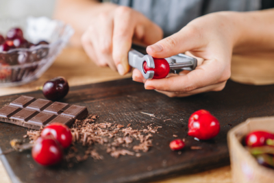 Jemand entkernt Bio-Kirschen.