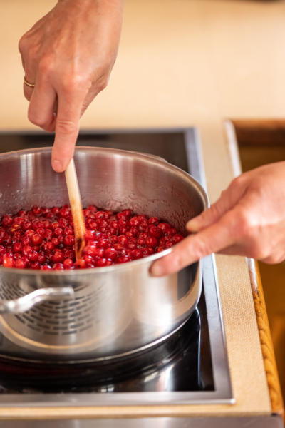 Ribisel werden in einem Topf umgerührt.