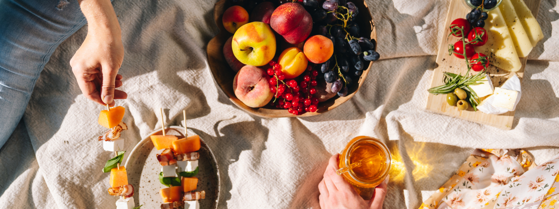 Jemand grieft nach Frucht Spießen daneben Bio-Früchte und Honig.