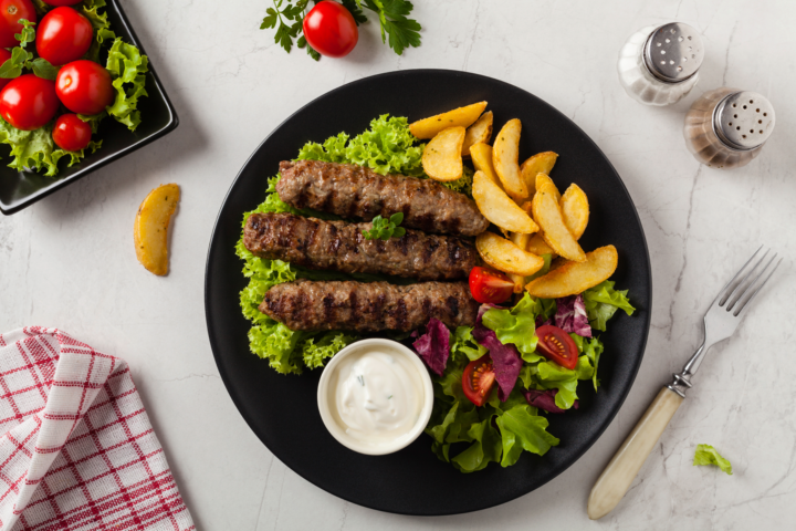 Bio-Cevapcici mit knusprigen Erdäpfel-Spalten und Joghurtdip