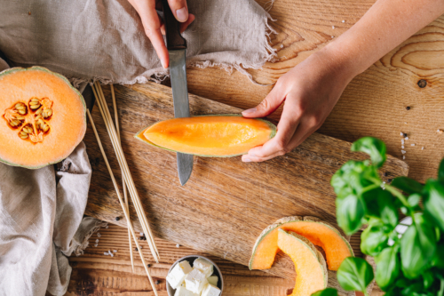 Eine Bio-Zuckermelone, die geschnitten wird.