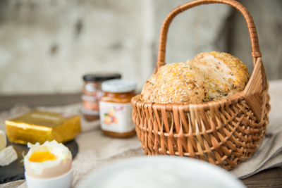 Ein Korb mit Brot, im Hintergrund Ja! Natürlich Bio-Aufstriche im Glas.