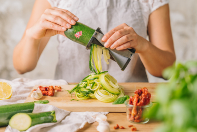 Jemand macht „Zoodels“ aus einer Ja! Natürlich Bio-Zucchini.