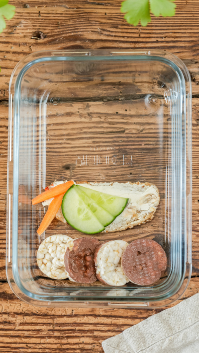 Ein Butterbrot mit Bio-Gemüse und Mini Schoko-Reiswaffeln in einer Glasschale.