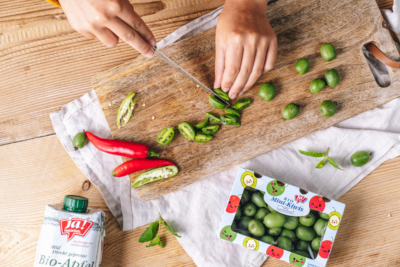 Jemand halbiert Ja! Natürlich Bio-Mini-Kiwis.