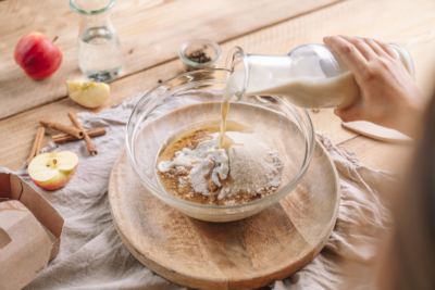 Jemand schüttet Bio-Milch in eine Schüssel.
