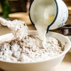 Jemand mixt den Teig für Schafgarbenbrot.