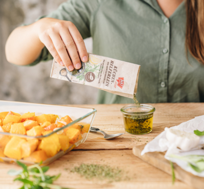 Jemand gibt Ja! Natürlich Bio-Küchenhelferlein in ein Glas mit Öl.