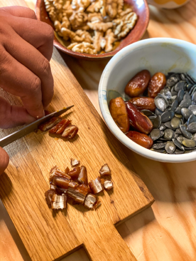 Jemand schneidet Bio-Datteln.