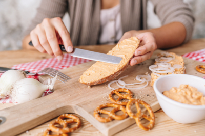Jemand schmiert sich ein Brot mit Obatzter.