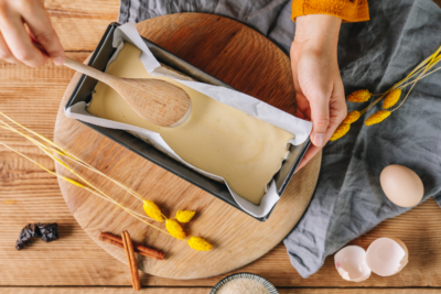 Jemand verstreicht Bio-Parfaitmasse in einer Kastenform.