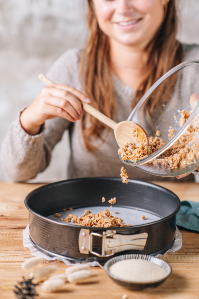 Jemand gibt Kuchenboden in eine Springform.