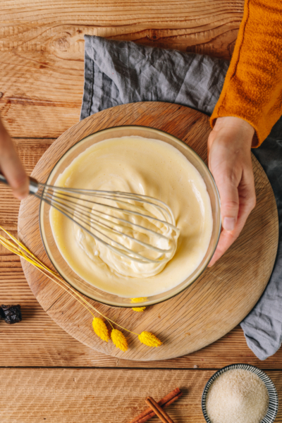 Jemand rührt mit einem Schneebesen die Bio-Parfaitmasse an.