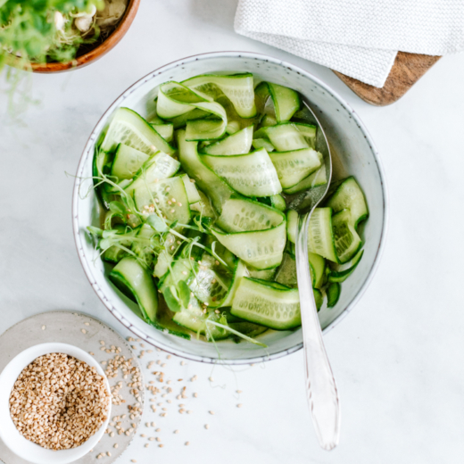 Bio-Gurkensalat mit einer Schale Sesam.