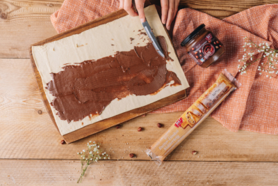 Jemand bestreicht Ja! Natürlich Bio-Butter-Dinkel-Blätterteig mit Nougatcreme.