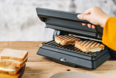 Jemand macht Bio-Käse-Toast im Toaster.