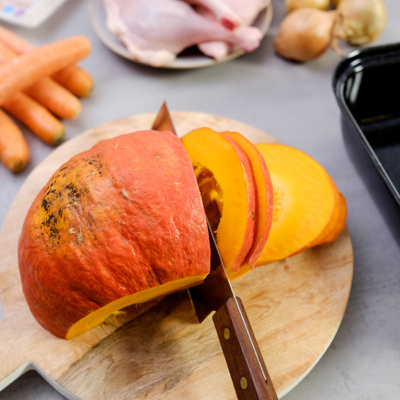 Jemand schneidet einen Bio-Kürbis.