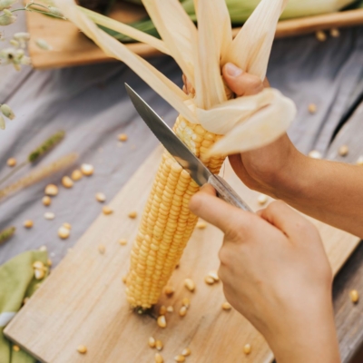 Jemand schält Bio-Mais.