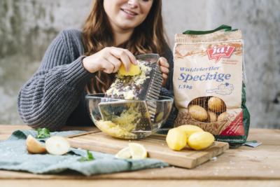 Jemand reibt Ja! Natürlich Bio-speckige Erdäpfel.