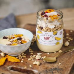 Ja! Natürlich Bio-Smoothie-Bowl To Go mit getrockneter Mango im Glas und daneben in einer Schüssel.
