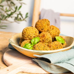Bio-Falafel-Bällchen mit Basilikum auf einem Tisch.