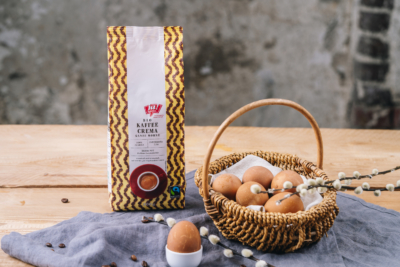 Eine Packung Ja! Natürlich Bio-Kaffee Crema und ein Korb Eier.