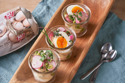 Ei-Gerichte in kleinen Gläsern, daneben ein Karton Ja! Natürlich Bio-Eier.