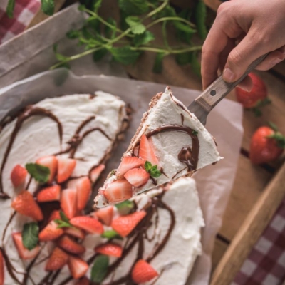 Schoko-Reiswaffel-Torte mit Bio-Erdbeeren, die serviert wird.