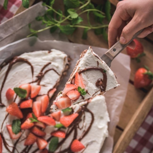 Schoko-Reiswaffel-Torte mit Bio-Erdbeeren, die serviert wird.