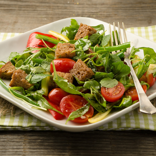 Ein Bio-Bohnen-Paprika-Brotsalat auf einem Teller.