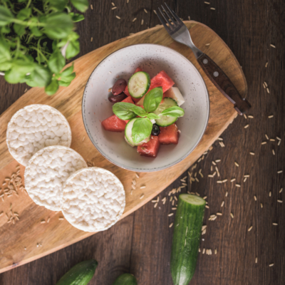 Ein Schneidbrett mit dünngeschnittenem Bio-Fenchel, dahinter weitere Zutaten.
