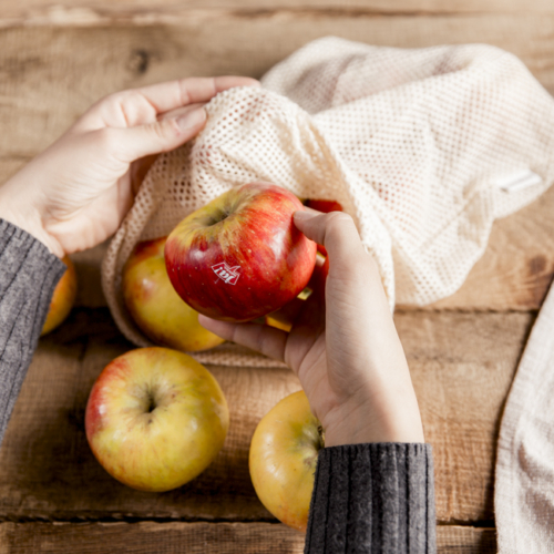 Jemand hat einen Bio-Apfel aus dem Sackerl genommen.