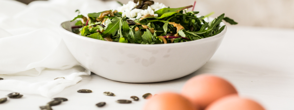 Eine Schüssel mit Bio-Ruccola-Salat und Kürbiskernen.