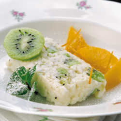 Bio-Kiwi-Milchreisterrine mit Orangensalat auf einem Teller.