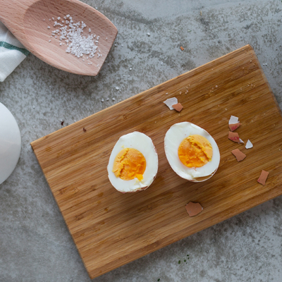Ein halbiertes, gekochtes Bio-Ei auf einem Schneidebrett.