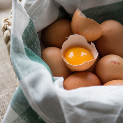 Bio-Eier in einem Sack, eines davon ist aufgebrochen.