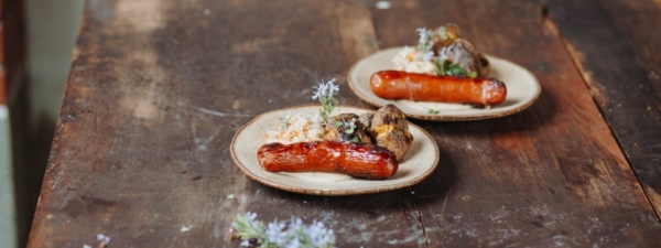 Käsekrainer mit Kräuter-Quetschkartoffel und Kohlrabi-Karotten-Coleslaw
