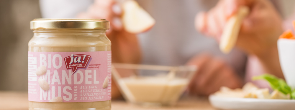 Ein Glas Ja! Natürlich Bio-Mandelmus im Vordergrund.