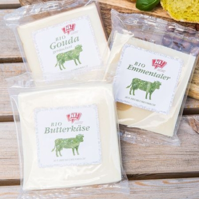Verschiedene Bio-Käsesorten von Ja! Natürlich auf einem Tisch.