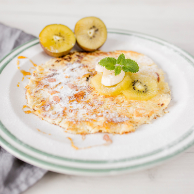 Bio-Topfen-Palatschinken auf einem Teller mit Goldkiwis.