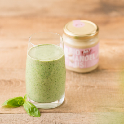 Ein grüner Smoothie mit einem Glas Ja! Natürlich Bio-Mandelmus.