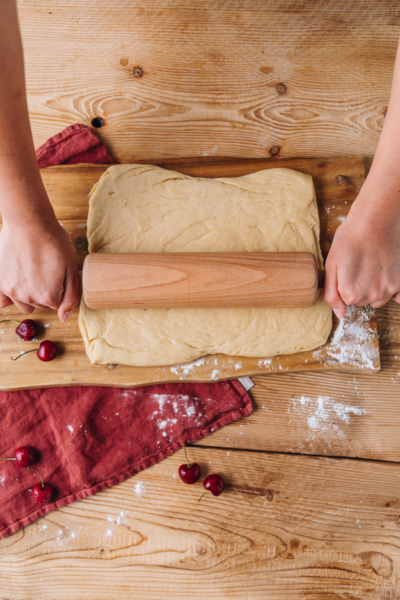 Jemand rollt Teig aus.