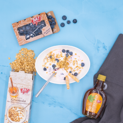 Selbstgemachtes Heidelbeereis mit Ja! Natürlich Bio-Ahornsirup, Granola und frischen Heidelbeeren.