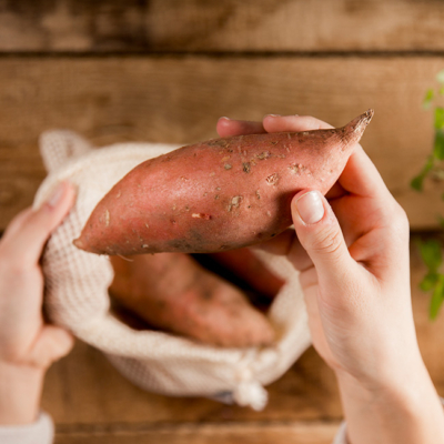 Jemand hat eine Bio-Süßkartoffel aus dem Sackerl genommen.