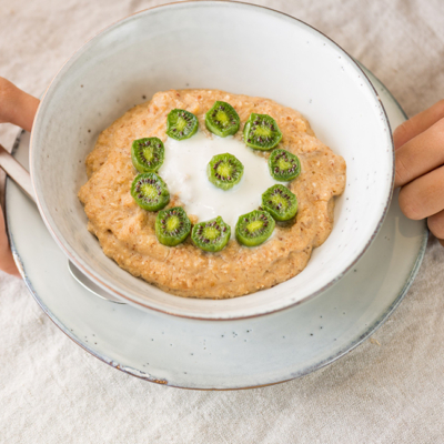 Eine Schüssel Bio-Porridge mit Mini-Kiwis.