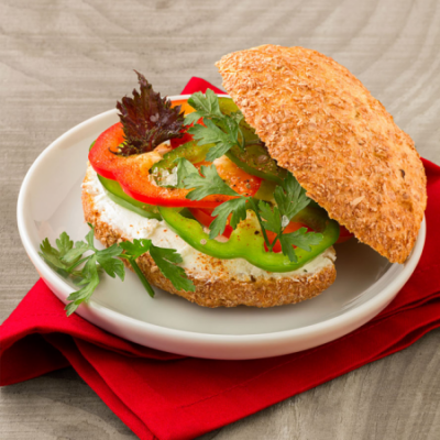Dinkelweckerl mit buntem Paprika und Topfenaufstrich auf einem Teller.